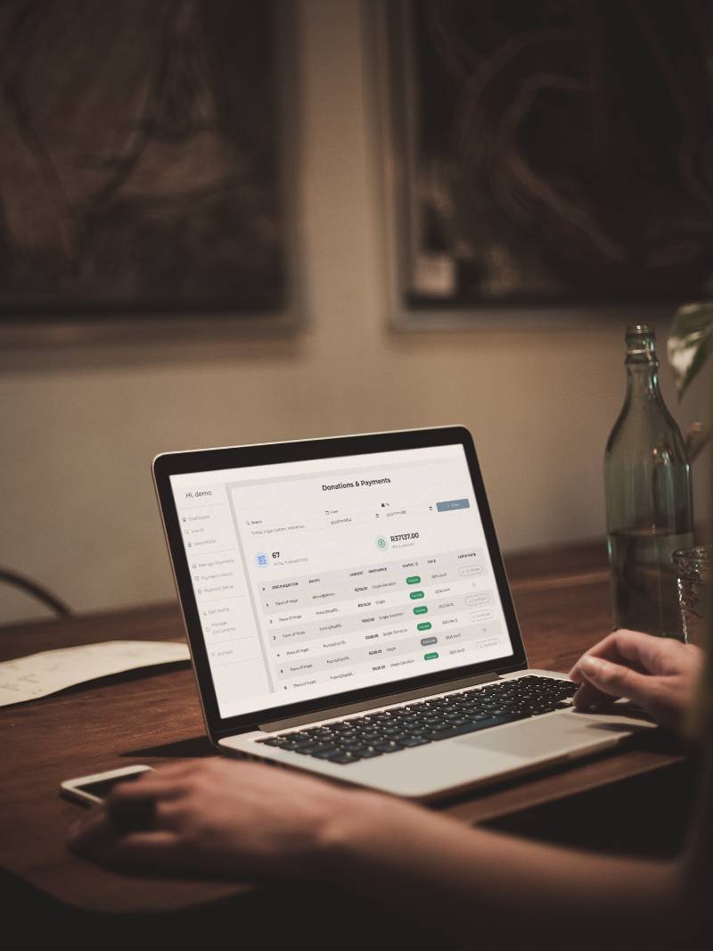 Charity staff reviewing donation reports on laptop